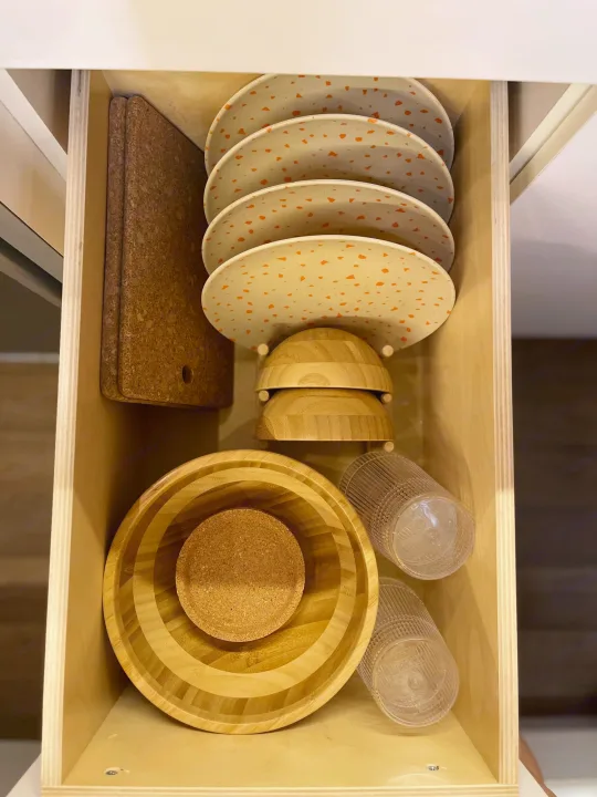 Efficient kitchen storage in an RV rental! Plates, wooden bowls, cork boards, and cups are neatly arranged in this drawer.. Dodge Ram Promaster 3500 C/V HR 159 EXT 2023