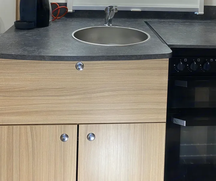 RV rental: Full galley kitchen with sink, faucet, coffee maker, stovetop, and oven. Compact design, wood cabinetry.. Bailey x 2022