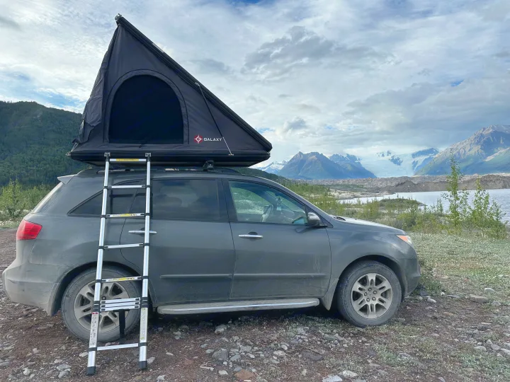 SUV with a rooftop tent, offering an RV rental-like camping experience. Parked by a stunning glacial lake & mountains.. Other Other 2007