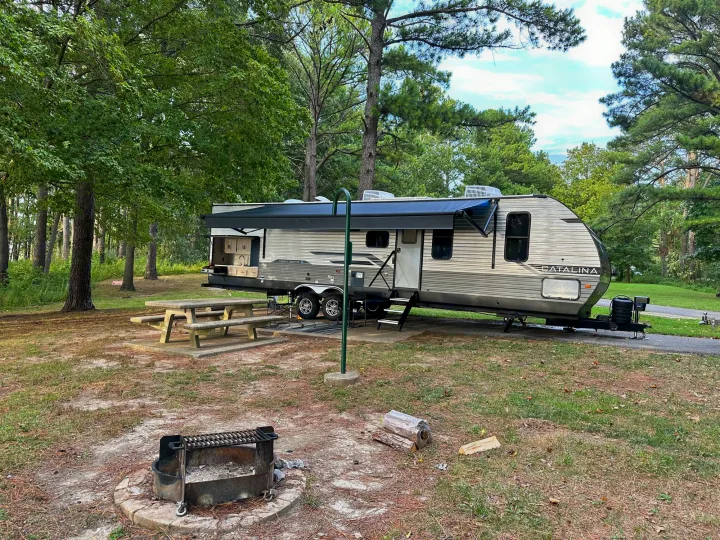 Spacious rv rental at a wooded campsite with picnic table, outdoor kitchen, and fire pit ready for fun.. Coachman Catalina, Legacy edition 343BHTS 2024