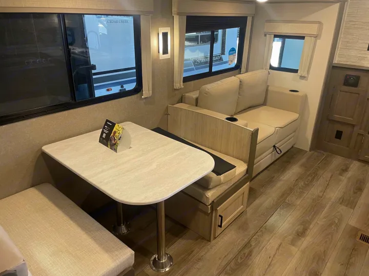 Modern RV rental interior: light-toned dinette with booth seating and a comfortable sofa-bed, ideal for travel.. Coachman Catalina, Legacy edition 343BHTS 2024