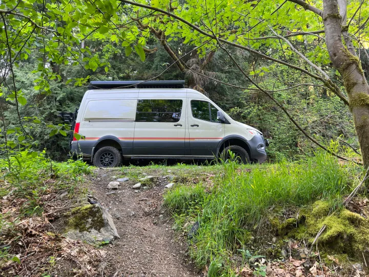 Camper van RV rental ready for adventure, parked in a lush forest. Ideal for outdoor exploration.. Mercedes-Benz Sprinter 2021