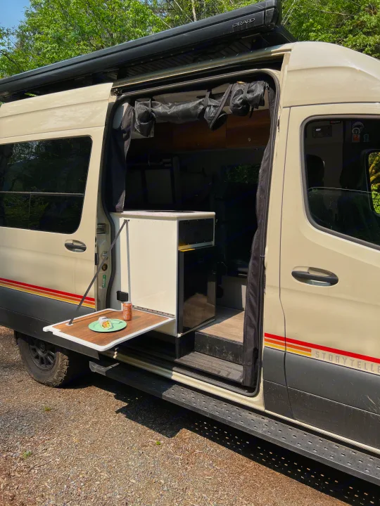 RV rental Storyteller camper van showcasing its convenient side table & interior. Ideal for road trips.. Mercedes-Benz Sprinter 2021