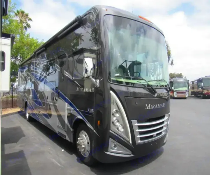 Sleek black and blue Miramar Class A motorhome, an ideal RV rental, parked outdoors, ready for adventure.. Thor Miramar 2022