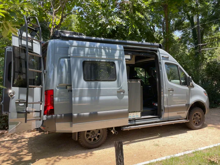Stylish gray Mercedes Sprinter RV camper van, perfect for an rv rental, with side and rear doors open.. Winnebago Revel 2023