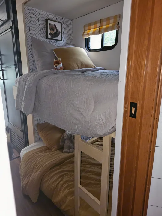RV rental: modern bunk beds with grey & gold bedding, nature-themed decor, and compact design.. Forest River Coachmen Freelander 2014