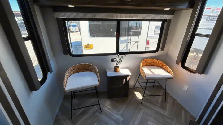 Step inside this modern RV rental featuring comfortable counter seating, a cozy table, and a clear view of fellow travel trailers.. Forest River Wildwood 2022