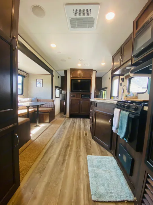 This bright RV rental interior showcases a modern kitchen, cozy dinette, and entertainment area.. Jayco Jay Flight SLX 2018