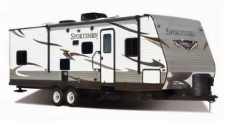 A white and brown Sportsmen travel trailer/RV, an excellent RV rental choice for camping trips. Adventure awaits!. KZ Sportsman 2015