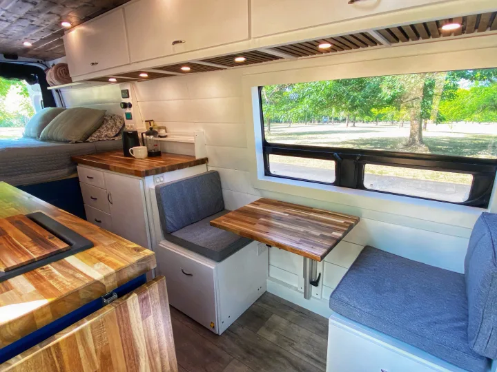 This camper van RV rental offers a cozy bed, kitchen, and dinette with refreshing park views. Ideal for travels.. Freightliner Sprinter 2020