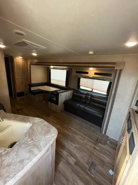 Bright rv rental interior featuring a modern kitchen, spacious dinette, and comfortable sofa, perfect for travel.. Coachmen Catalina 2019