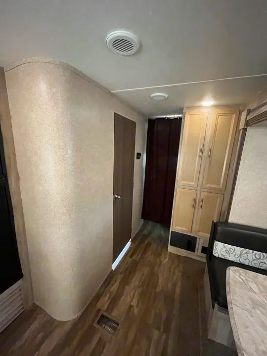 RV rental interior view: light-toned walls, wood-look floor, wood cabinets, and a dining nook.. Coachmen Catalina 2019