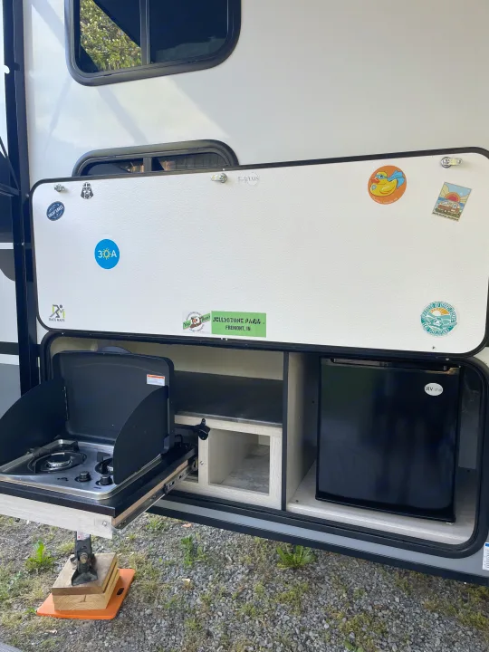 RV rental outdoor kitchen with pull-out cooktop, mini-fridge, and storage. Perfect for camping!. Coachmen Apex Nano 2023