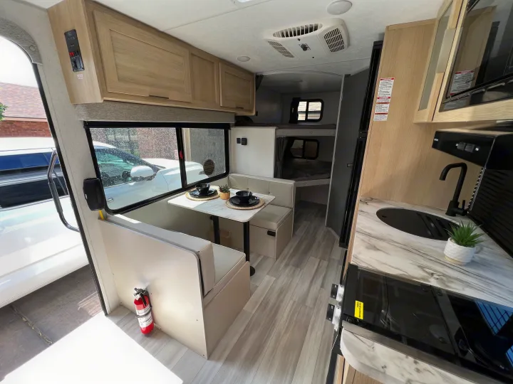 Step inside this RV rental, featuring a cozy dinette, modern kitchen, and comfortable bunk beds for your next adventure.. Forest River Salem FSX 2023