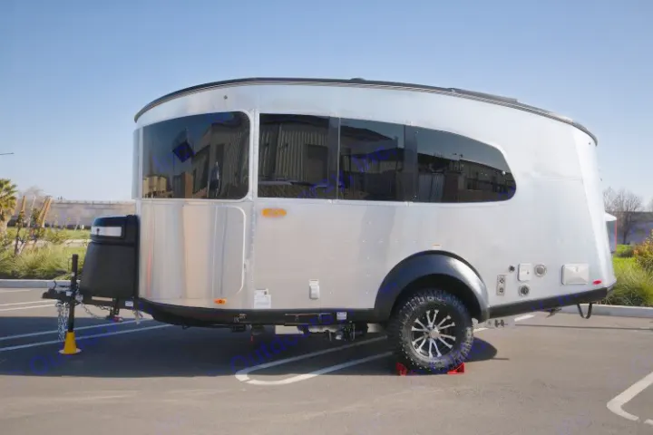 Sleek, silver travel trailer, ideal for an RV rental, parked on asphalt. A modern compact RV ready for adventure.. Airstream Base Camp 2022