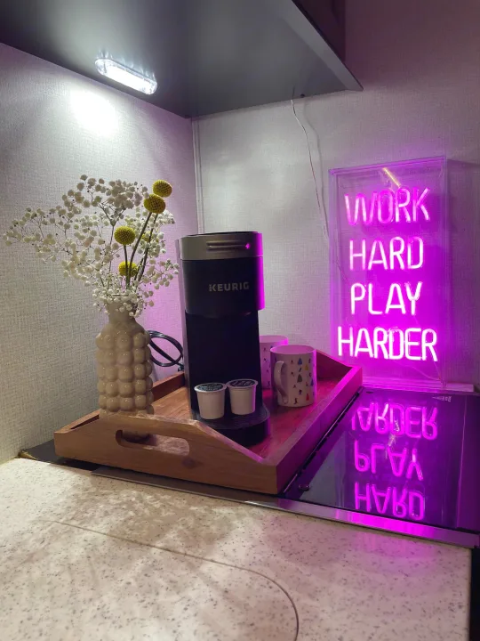 Cozy RV rental coffee station featuring a Keurig, flowers, and a vibrant "WORK HARD PLAY HARDER" neon sign.. Forester Classic 2021
