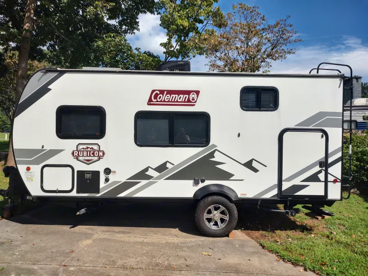 Sleek white & grey Coleman Rubicon travel trailer, parked outdoors. An ideal rv rental for your next adventure.. Dutchmen Coleman Rubicon 2021