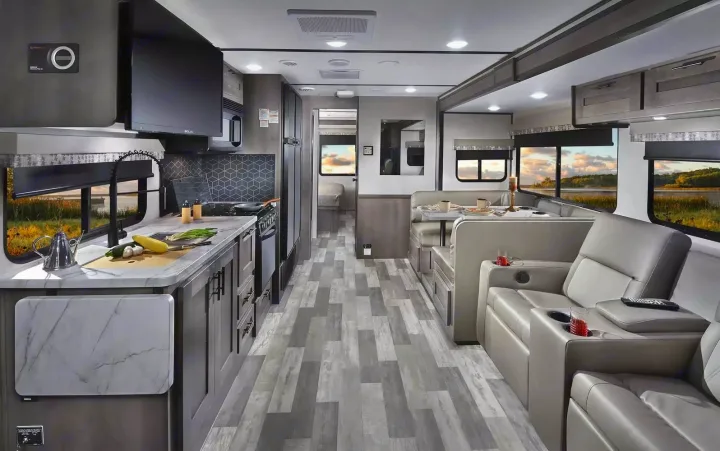 Explore this modern RV rental interior featuring a full kitchen, dining booth, comfy recliners, and bright windows.. Forest River 34DS 2022