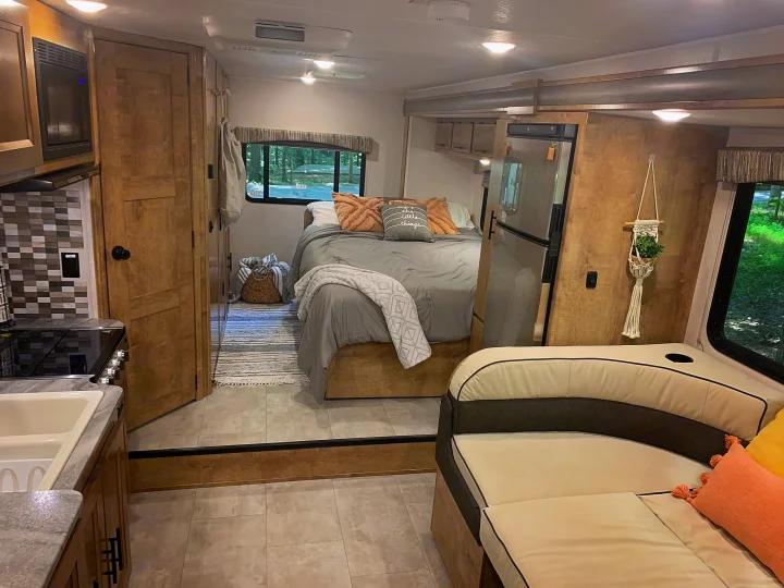 Functional RV rental interior featuring a well-appointed kitchen, inviting bedroom with window views, & comfortable living area.. Forest River Coachmen Leprechaun 2020