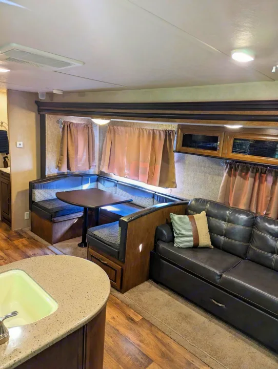 Spacious RV rental interior featuring a comfortable dinette, sofa, and kitchen island. Ideal for travel.. Forest River Salem 2017