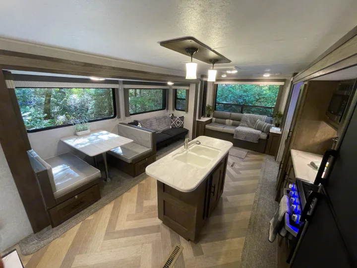 Spacious & modern RV rental interior with full kitchen, dining booth, and cozy living area, perfect for travel.. Forest River Salem 2021