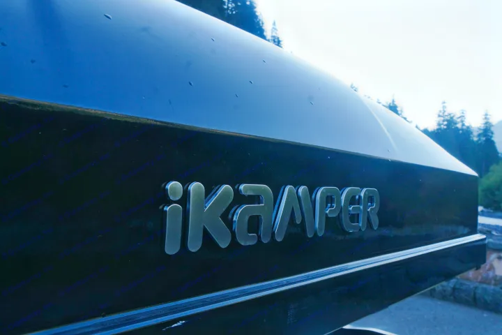 Close-up of a black iKamper roof-top tent with metallic logo. Ideal for outdoor camping adventures, often offered by rv rental services.. Subaru Outback with iKamper 2017