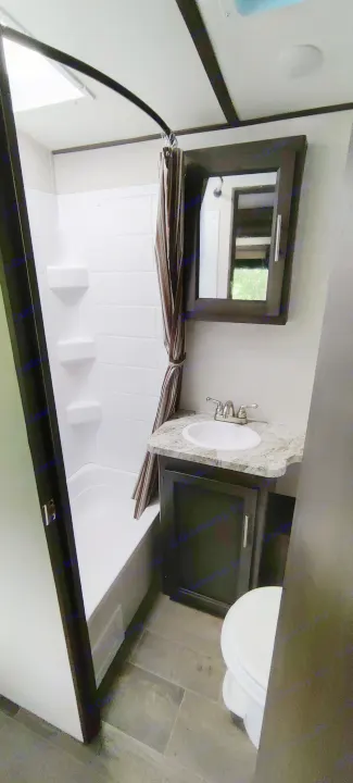 Modern RV rental bathroom with tub/shower, vanity, and toilet for compact comfort.. Crossroads RV Sunset Trail Super Lite 2021