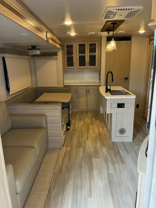 Explore this bright, modern RV rental interior with a comfy sofa, U-shaped dinette, and functional kitchen space.. Forest River Flagstaff Classic 2022
