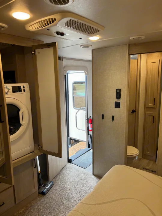 Inside this RV rental: compact laundry, efficient living space, small bathroom, and main entry.. Forest River Flagstaff Classic 2022