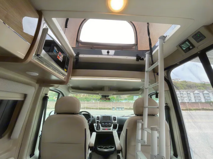 RV rental interior: Front cabin with microwave, ladder to pop-top, and controls. Ready for your next adventure.. Thor Scope 2023