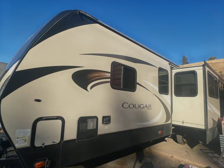 Spacious Cougar fifth-wheel travel trailer for RV rental, with windows and an extended slide-out, ready for adventure.. Keystone RV Cougar 2019
