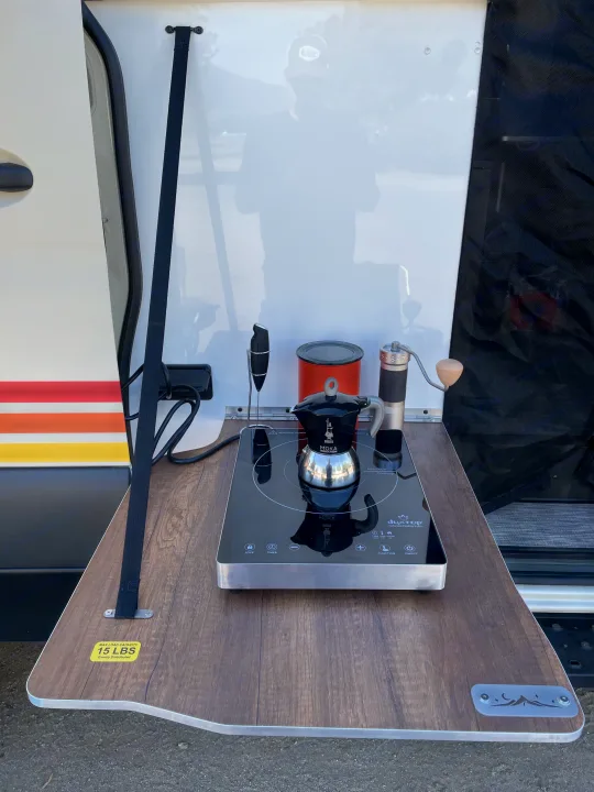 RV rental outdoor coffee setup featuring a DuxTop induction cooktop, Bialetti Moka pot, and grinder for roadside brews.. Storyteller Overland Storyteller Overland Class B 2022