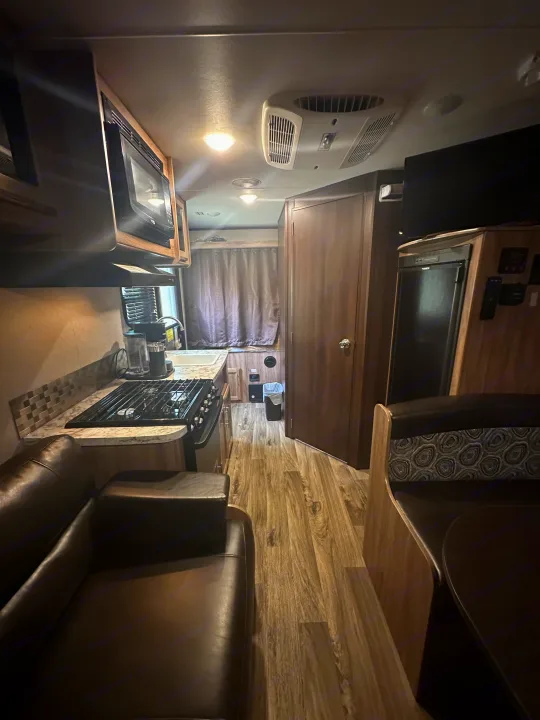 Spacious rv rental interior featuring a full kitchen, cozy living area, and dinette. Perfect for your next road trip adventure!. Jayco Jay Feather 2018