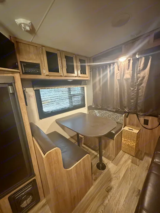 Inside an RV rental: Modern dinette, overhead cabinets, and essential amenities in a compact, functional living space.. Jayco Jay Feather 2018