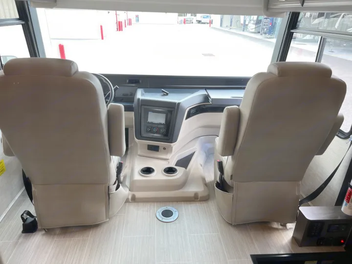 RV rental interior: front view of two captain's chairs, dashboard, and driving console, ready for adventure.. Entegra Coach Vision XL 2023