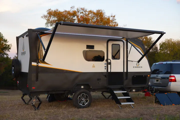 This Ember RV rental is set up with an awning & portable solar panels in a scenic outdoor setting, perfect for your next camping trip.. Ember Overland 2022