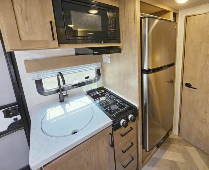 RV rental: Fully equipped RV kitchen with microwave, stove, sink, and stainless steel fridge.. Ember Overland 2022