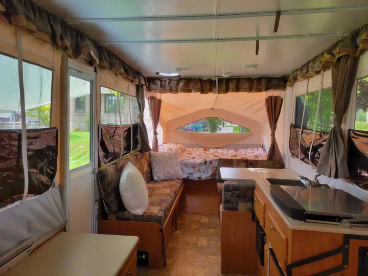 Step inside this cozy pop-up camper RV rental, featuring a comfortable bed, dinette, and compact kitchen area.. Forest River Flagstaff M.A.C. 2011