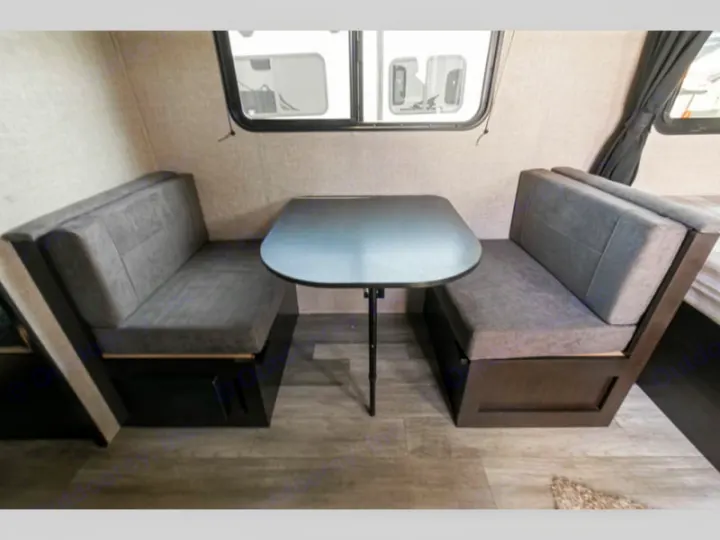 Inside an RV rental: a practical dinette with upholstered grey benches, a removable table, and built-in storage.. Jayco Jay Flight SLX STX Edition 2022