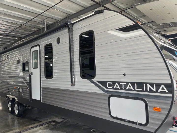 Two-axle grey Catalina travel trailer, ideal for rv rental. Parked indoors; awning retracted.. Coachman Catalina, Legacy edition 343BHTS 2024