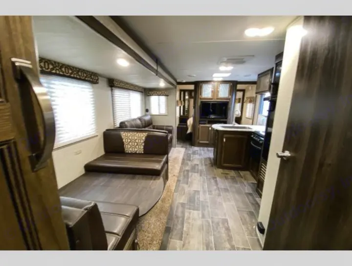 Spacious RV rental with a modern interior. Features include a living area with dinette and sofa, and a well-equipped kitchen.. Keystone RV Bullet Ultra Lite 2018