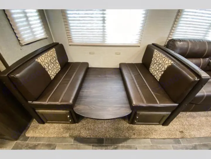RV rental interior: cozy dinette area with opposing brown benches, patterned cushions, and a central table.. Keystone RV Bullet Ultra Lite 2018