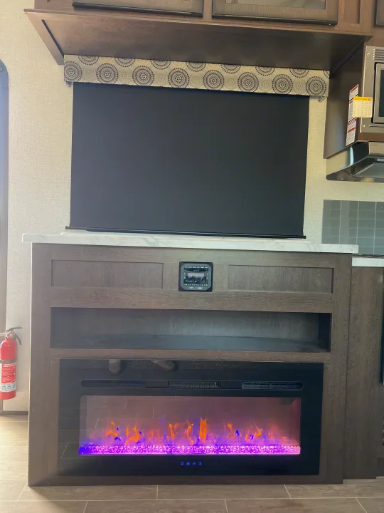 This RV rental offers a well-equipped living area with a large TV, Jensen control panel, and vibrant electric fireplace.. Atlas Atlas Fifth Wheel 2020