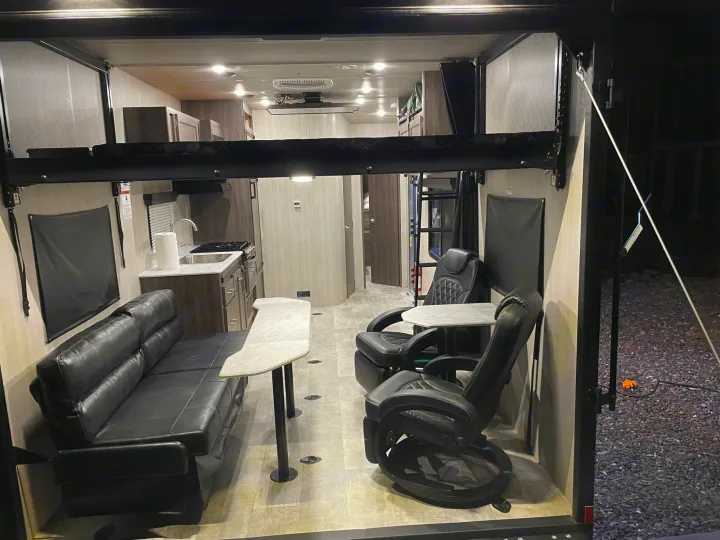 Spacious RV rental interior with black leather sofa, recliners, kitchen, and flexible living area.. Genesis Supreme Rv Genesis Supreme 2022