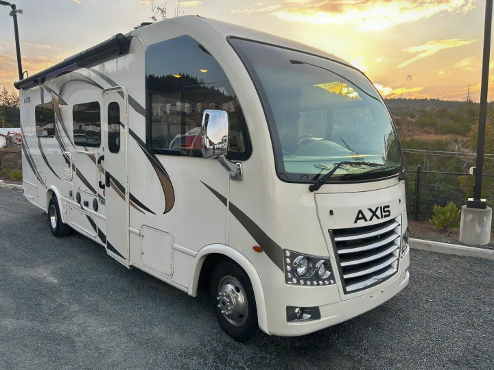 A modern Axis RV rental, parked on gravel at sunset, ready for your next outdoor travel adventure.. Thor Axis 2018
