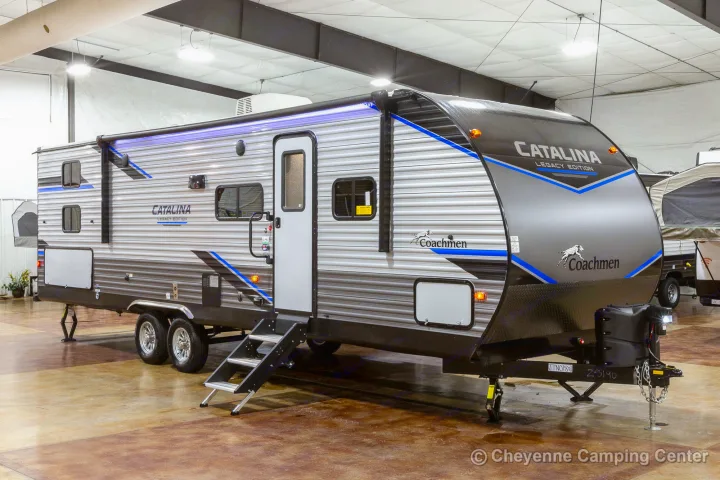 Sleek Coachmen Catalina Legacy Edition travel trailer in a showroom, perfect for an RV rental adventure. Steps and awning.. Coachmen Catalina 2022