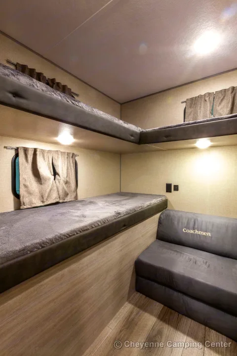Spacious RV rental bunkhouse area featuring comfy bunk beds and a sofa for travel adventures.. Coachmen Catalina 2022