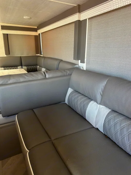 Modern **RV rental** interior showcasing a gray U-shaped dinette, table, and windows with blinds. Spacious seating for your adventures.. Forest River Salem Cruise Lite 2021