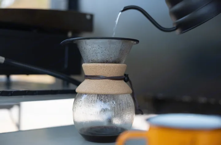 Pour-over coffee brewing in an RV rental, with water pouring into the filter. Fresh brew for your adventure.. Ember Overland 2022