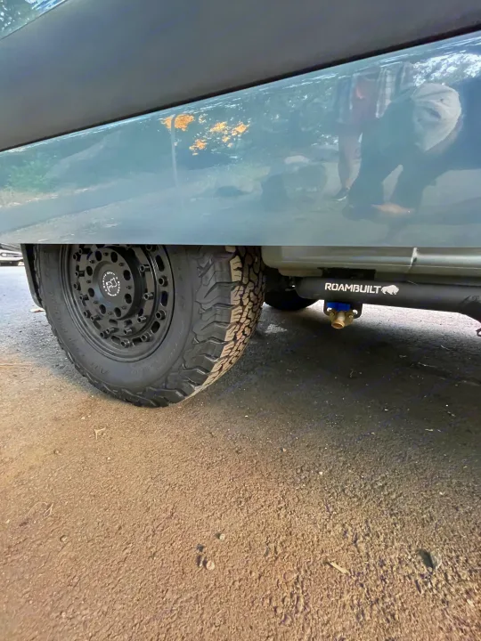Low-angle view of an RV rental. Features a Black Rhino wheel & ROAMBUILT undercarriage water system with spigot.. Mercedes-Benz Sprinter RV Motorhome Campervan 2020